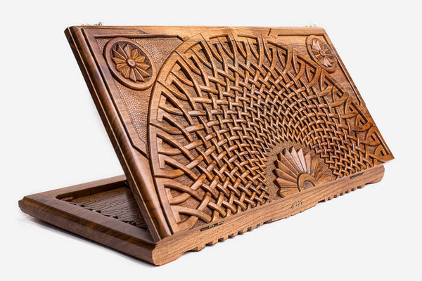 Master-carved walnut backgammon board with a woven infinity fan design, propped open