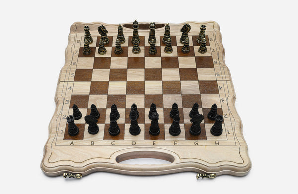Luxury classic walnut chess set with ornate bronze pieces, the gold army facing the black army in starting position