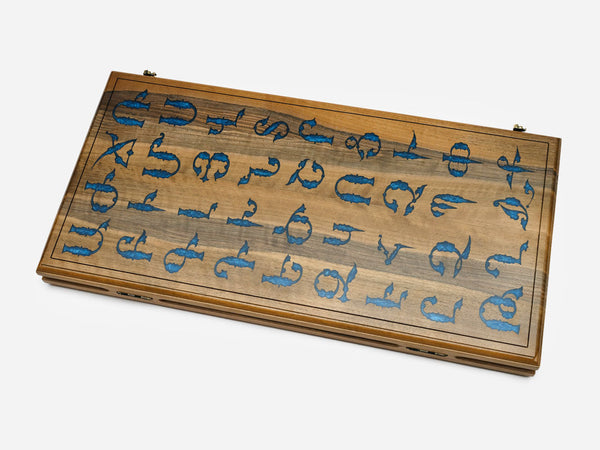 Walnut backgammon board with the Armenian alphabet inlaid in blue epoxy across the closed lid
