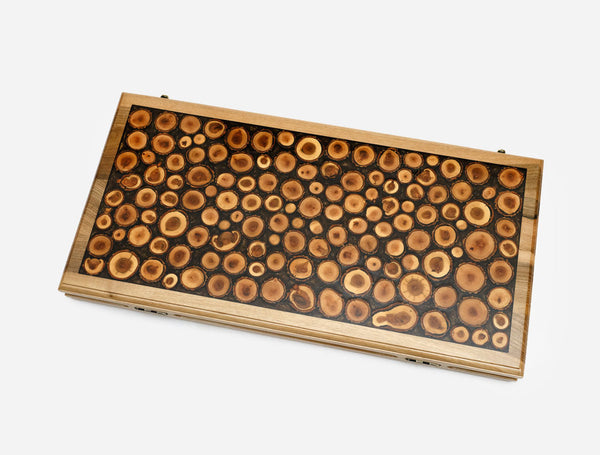 Folding walnut backgammon board with a mosaic of wood log slices cast in dark epoxy, shown closed at an angle