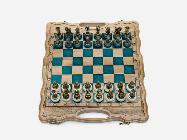 Luxury turquoise epoxy chess set opened flat with ornate bronze pieces on cream bases