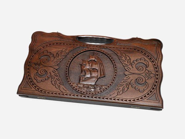 Carved beechwood backgammon board with a sailing ship, propped open