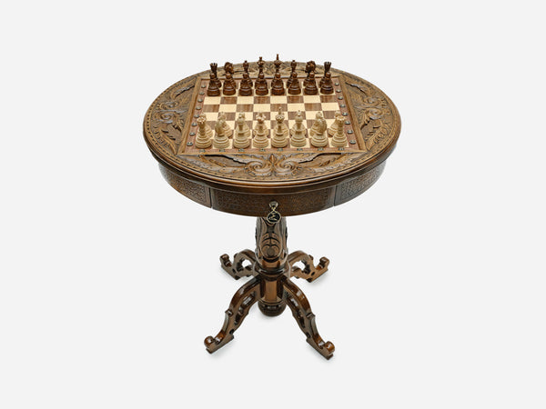Hand-carved round wooden chess table with a full chess set arranged on the board