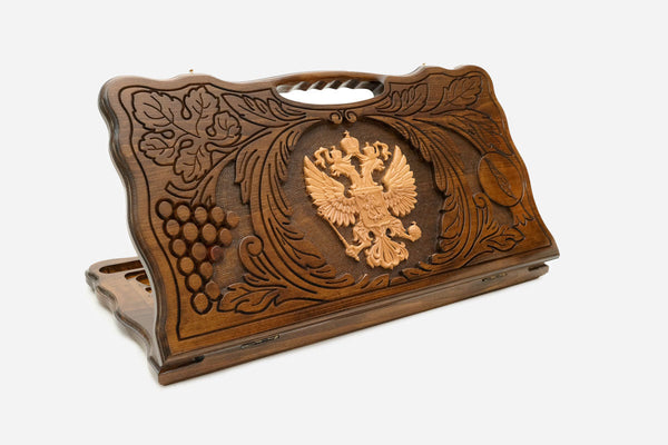 Carved Russian backgammon board with the double-headed eagle in a wreath of grapevines, cut-out carry handle, propped open