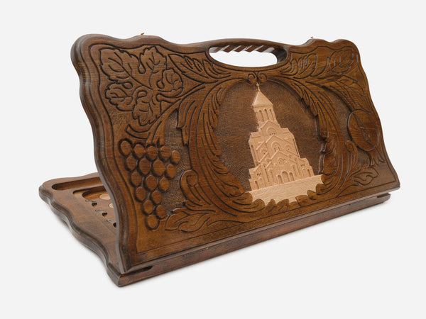 Carved Georgian backgammon board with Sameba Cathedral wreathed in grapevines, cut-out carry handle, propped open