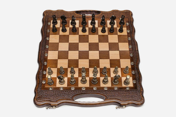 Luxury walnut chess set with carved corners and ornate bronze pieces, the gilded and darkened armies in starting position