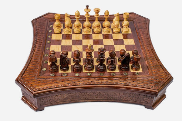 Curved-side wooden chess set with diamond-lattice border and wooden pieces set up on the inlaid board