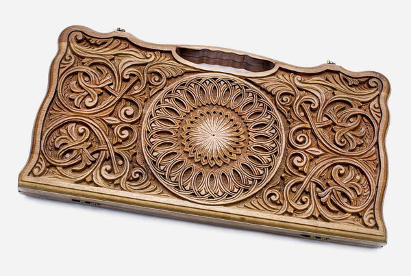 Master-carved walnut backgammon board with a blooming central ornament and scrollwork, propped open