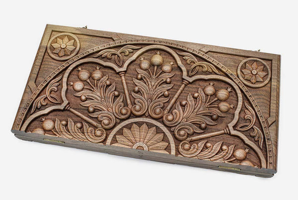 Master-carved walnut backgammon board with a pomegranate ornament, propped open