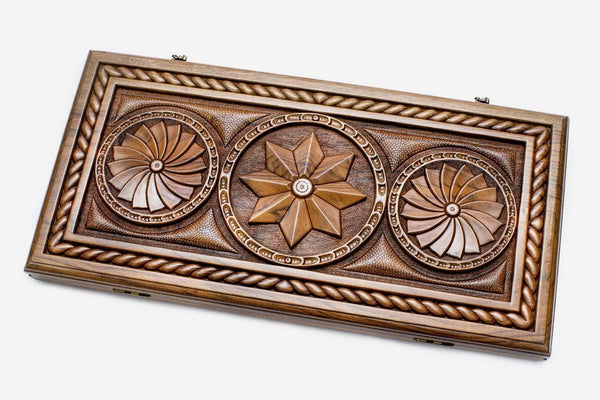 Master-carved walnut backgammon board with an octagon and infinity pattern, propped open