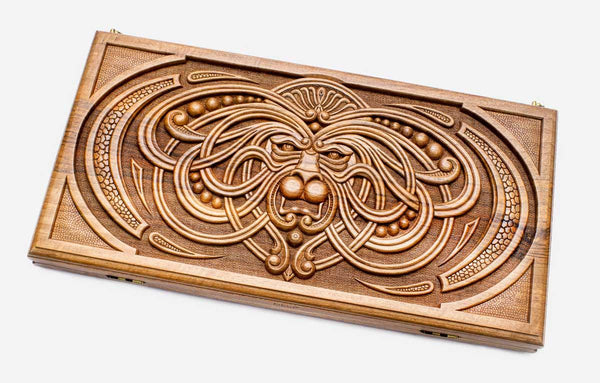 Master-carved walnut backgammon board with a symmetrical carved mask, propped open