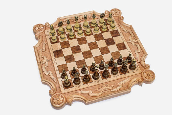 Luxury carved chess set in pale maple with corner ornament, ribbon scrollwork and a carved royal crown, set with bronze-topped pieces