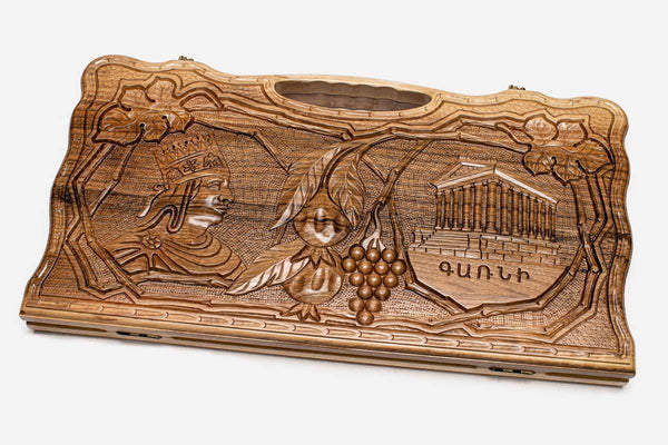 Carved walnut backgammon board with four carved scenes and a carry handle, propped open