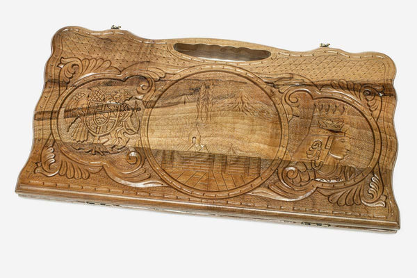 Carved walnut backgammon board with three carved scenes and a carry handle, propped open