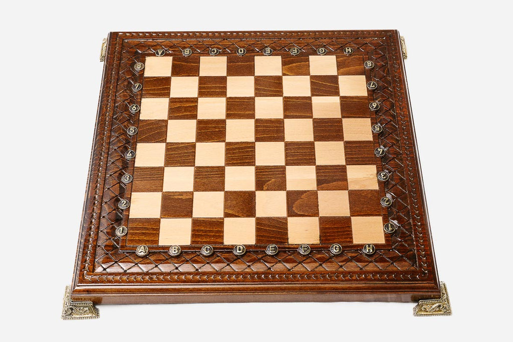 Carved wooden chess set shown folded with bronze clasps