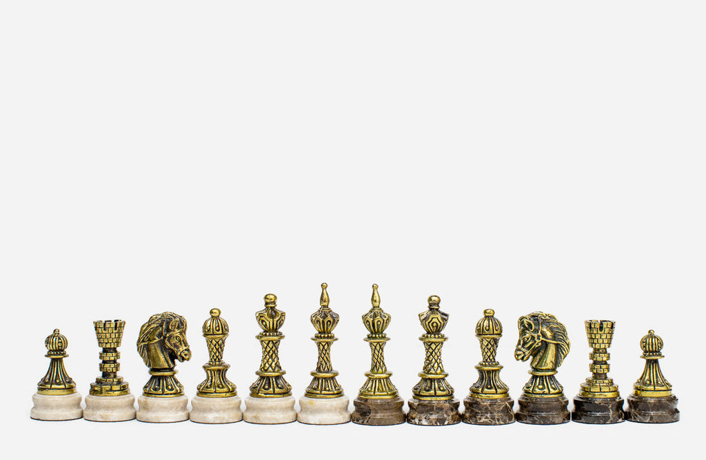Row of the two-tone bronze chess pieces on marble bases, showing kings, queens, bishops and horse-head knights