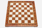 Top-down view of the empty coral and cream marble chess board with brass coordinate markers