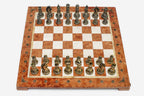 Row of the two-tone bronze chess pieces showing kings, queens, bishops, horse-head knights and rooks