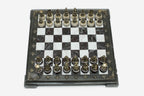 Burgundy and white marble chess set with hand-cast bronze pieces arranged for play and brass coordinate markers
