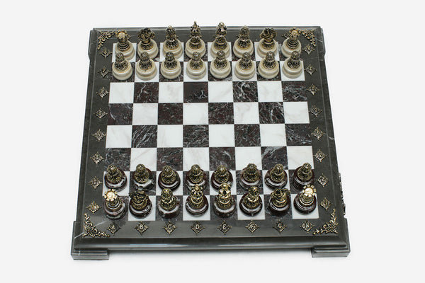 Burgundy and white marble chess set with hand-cast bronze pieces arranged for play and brass coordinate markers