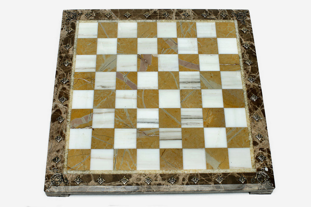 Golden and white marble chess set with bronze pieces on display