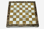 Golden and white marble chess set with bronze pieces on display