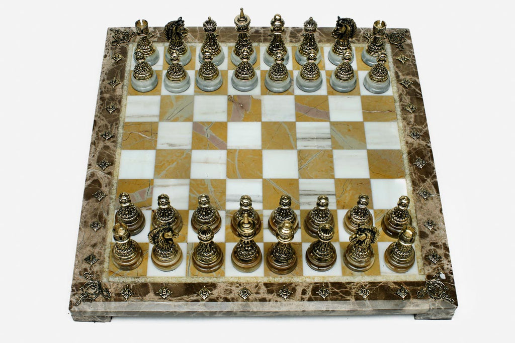 Golden marble chess set with hand-cast bronze pieces arranged for play and brass coordinate markers