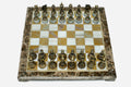 Golden marble chess set with hand-cast bronze pieces arranged for play and brass coordinate markers