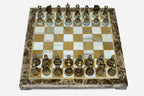 Golden marble chess set with hand-cast bronze pieces arranged for play and brass coordinate markers