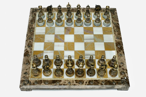 Golden marble chess set with hand-cast bronze pieces arranged for play and brass coordinate markers
