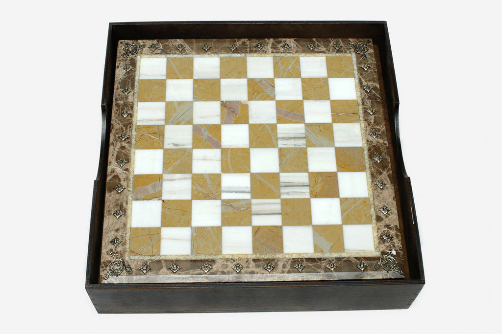 Golden and white marble chess board with hand-cast bronze pieces