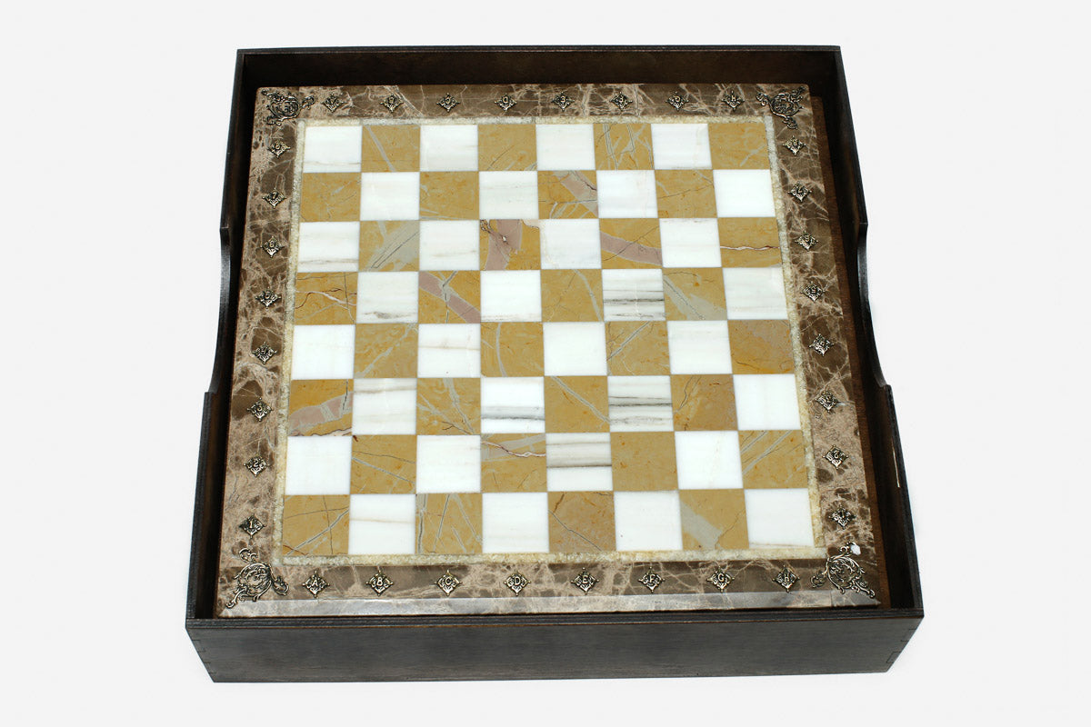 Golden and white marble chess board with hand-cast bronze pieces
