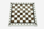 Top-down view of the empty cream and brown marble chess board with brass coordinate markers
