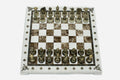 Cream and brown marble chess set with hand-cast bronze pieces arranged for play and brass coordinate markers