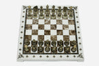 Cream and brown marble chess set with hand-cast bronze pieces arranged for play and brass coordinate markers