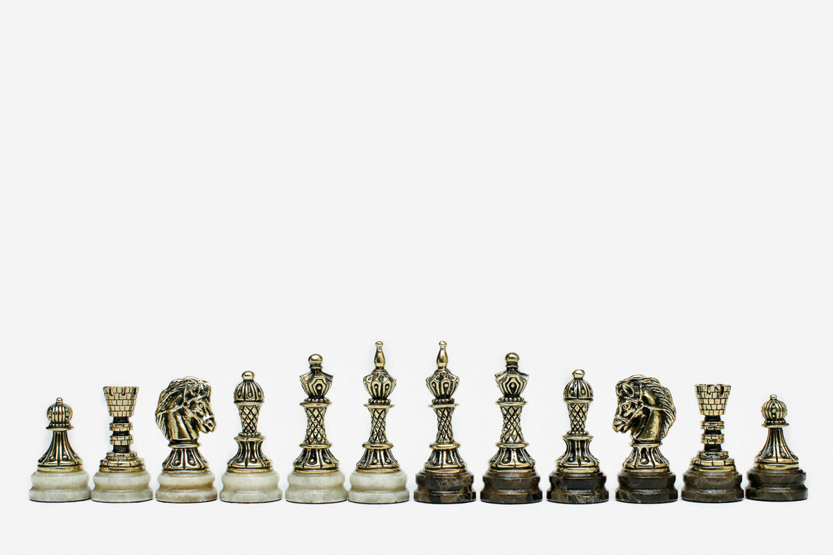 Row of the two-tone bronze chess pieces on marble bases, showing kings, queens, bishops and horse-head knights