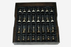 The full set of bronze chess pieces arranged in the black satin-lined wooden storage box