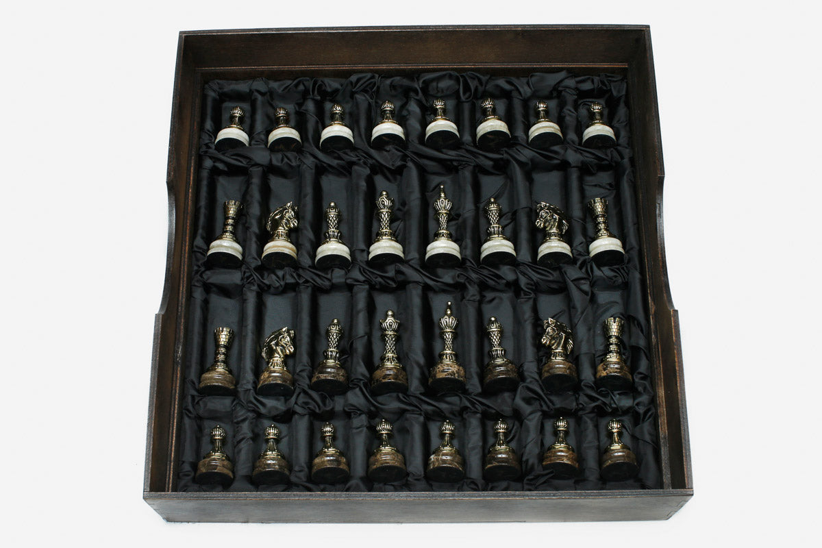 The full set of bronze chess pieces arranged in the black satin-lined wooden storage box