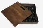 Wooden storage box open beside the marble board, showing the bronze chess pieces wrapped in black satin