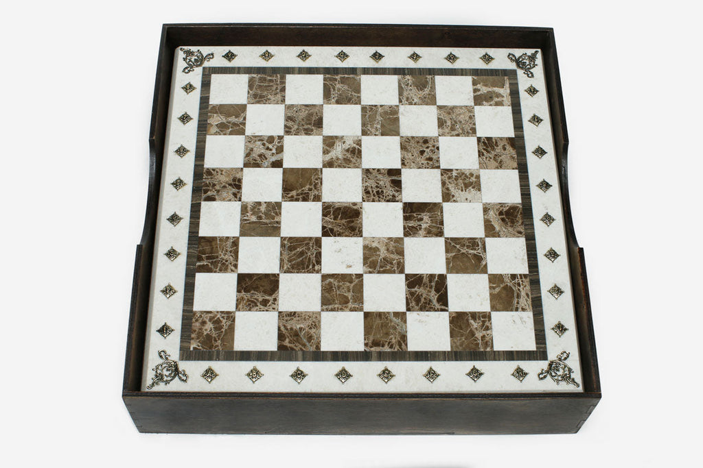 Top-down view of the cream-bordered brown marble chess board resting in its wooden case