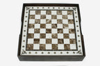 Top-down view of the cream-bordered brown marble chess board resting in its wooden case