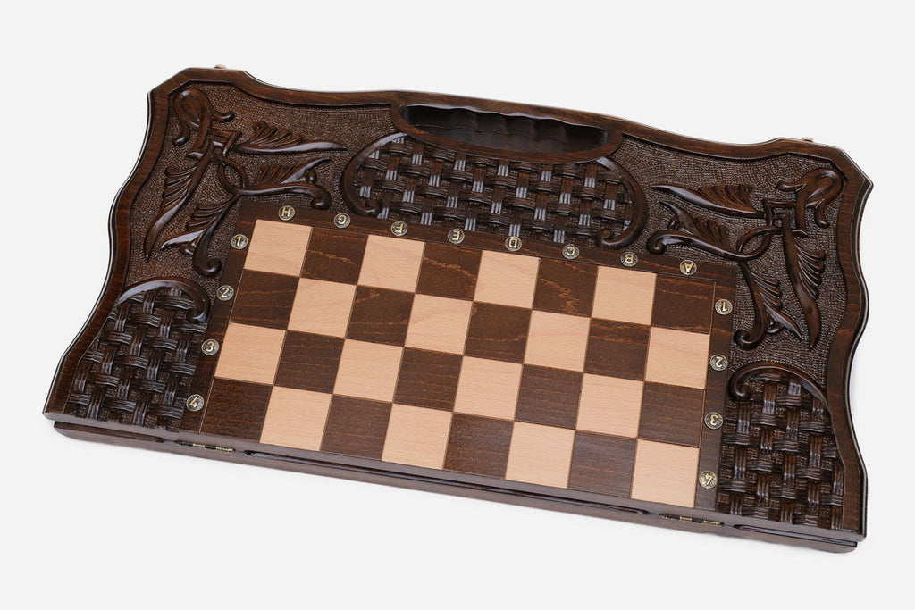 The carved chess set shown closed and ready to carry by its handle