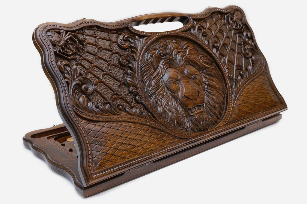Carved beechwood backgammon board with a lion and spider webs, with a carry handle, propped open