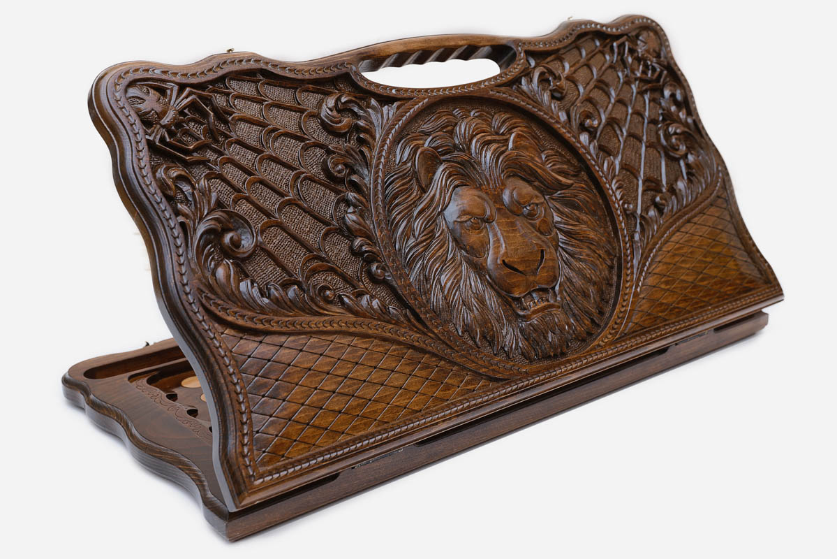 Carved beechwood backgammon board with a lion and spider webs, with a carry handle, propped open