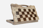Angled view of the folding walnut chess board with its gold and black metal pieces