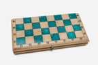 The teal epoxy chess set shown from an angle