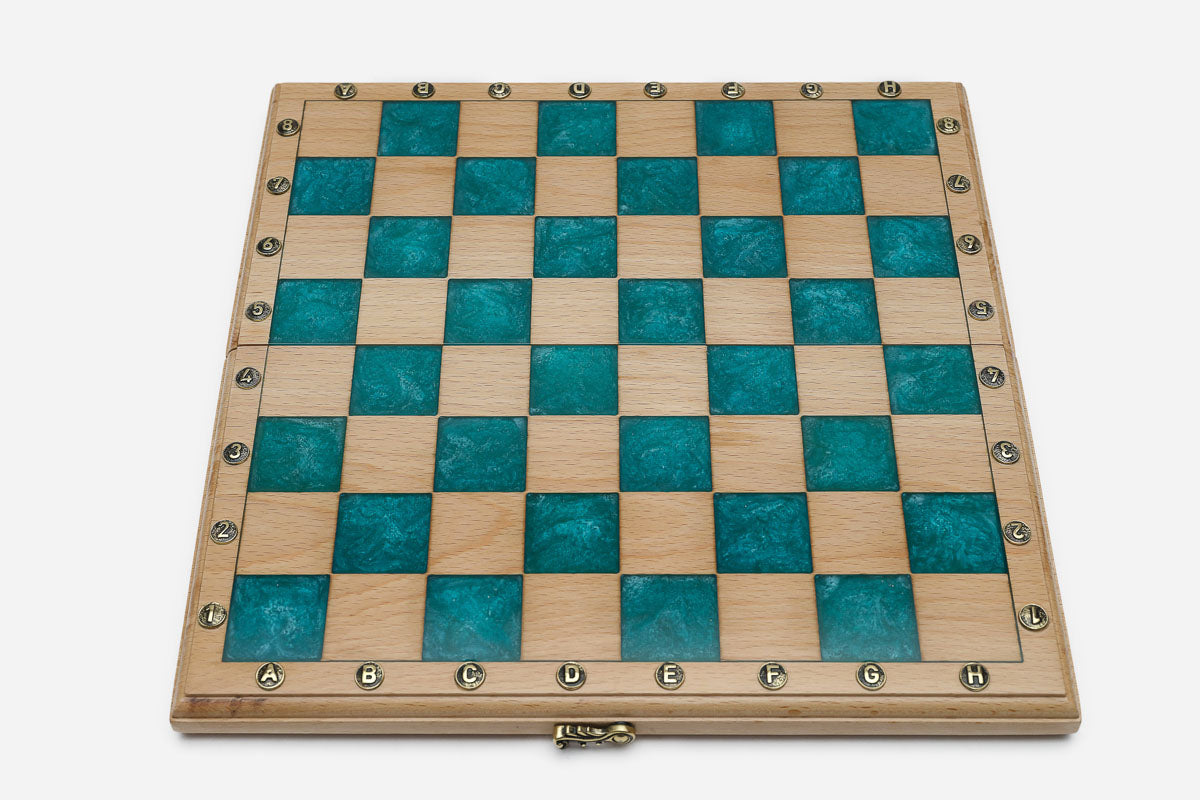 Overhead view of the empty teal epoxy chessboard with brass coordinate markers