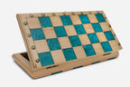 Angled view of the teal epoxy chess set with its bronze pieces