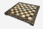 Angled view of the empty brown and cream marble chess board with brass markers