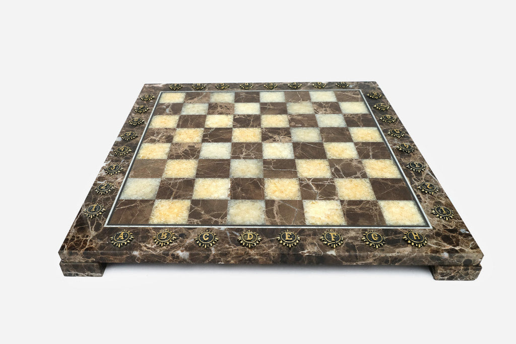 Front view of the brown marble chess board framed by brass letter and number markers